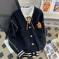 Sweet Teddy Bear Cardigan black edition with a bear sown into the chest area whilst the sleeves have large white stitches where they have been joined and black strips on the wrist cuffs with white, black and white trim.
