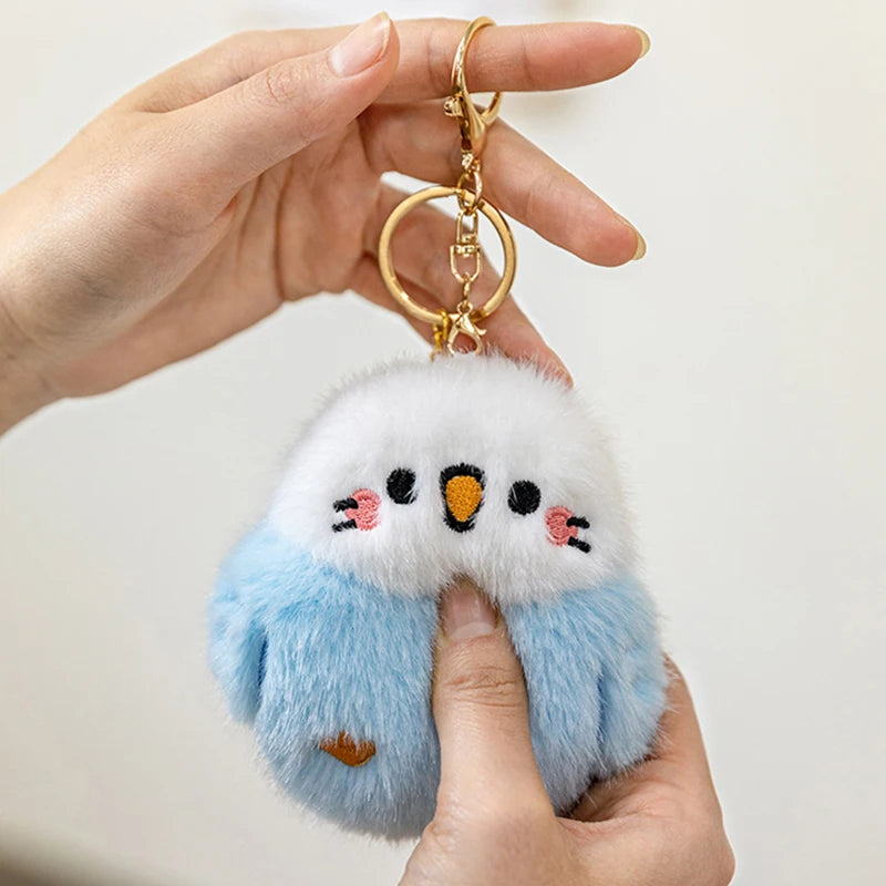 hand s holding kawaii blue and white bird plushie pendant keychain