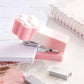Kawaii Pastel Cat Paw Stapler, this image is showing the Pink option of the stapler in use on a cute note book.