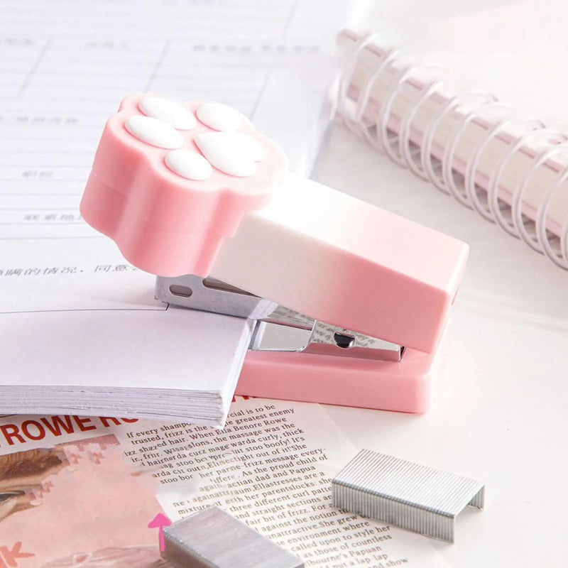 Kawaii Pastel Cat Paw Stapler, this image is showing the Pink option of the stapler in use on a cute note book.