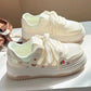 White sneakers with cartoon designs on a white surface
