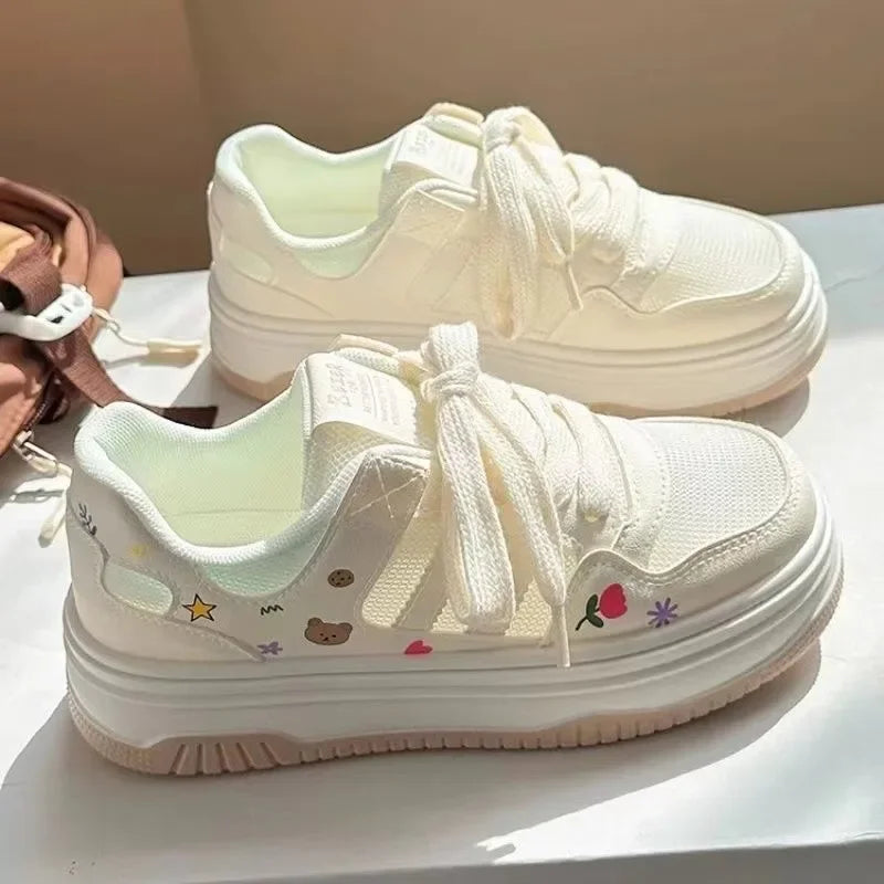 White sneakers with cartoon designs on a white surface