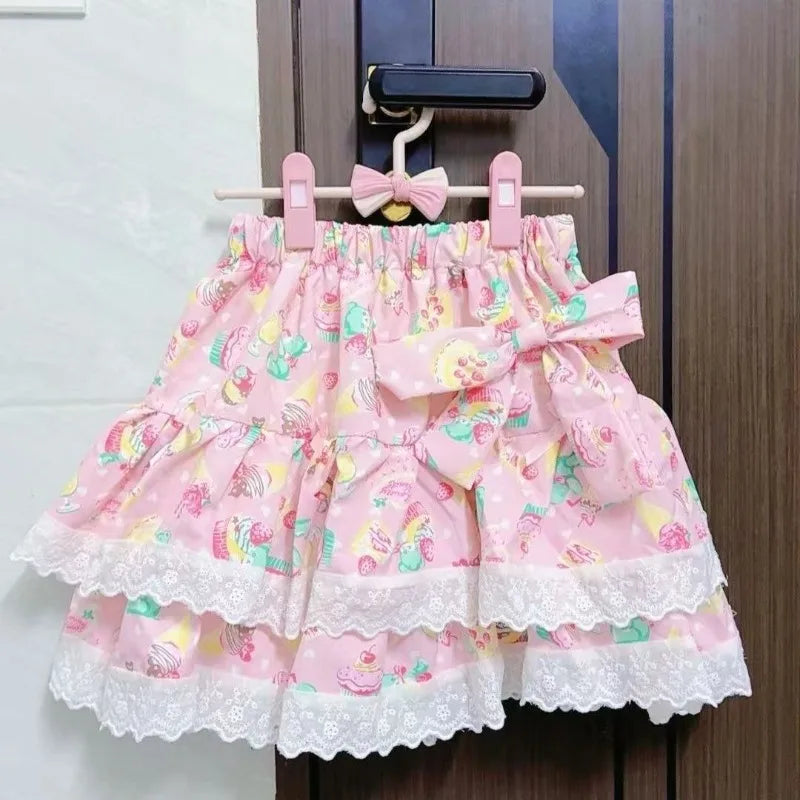 Pink skirt with floral pattern and bow on a hanger against a wooden door.