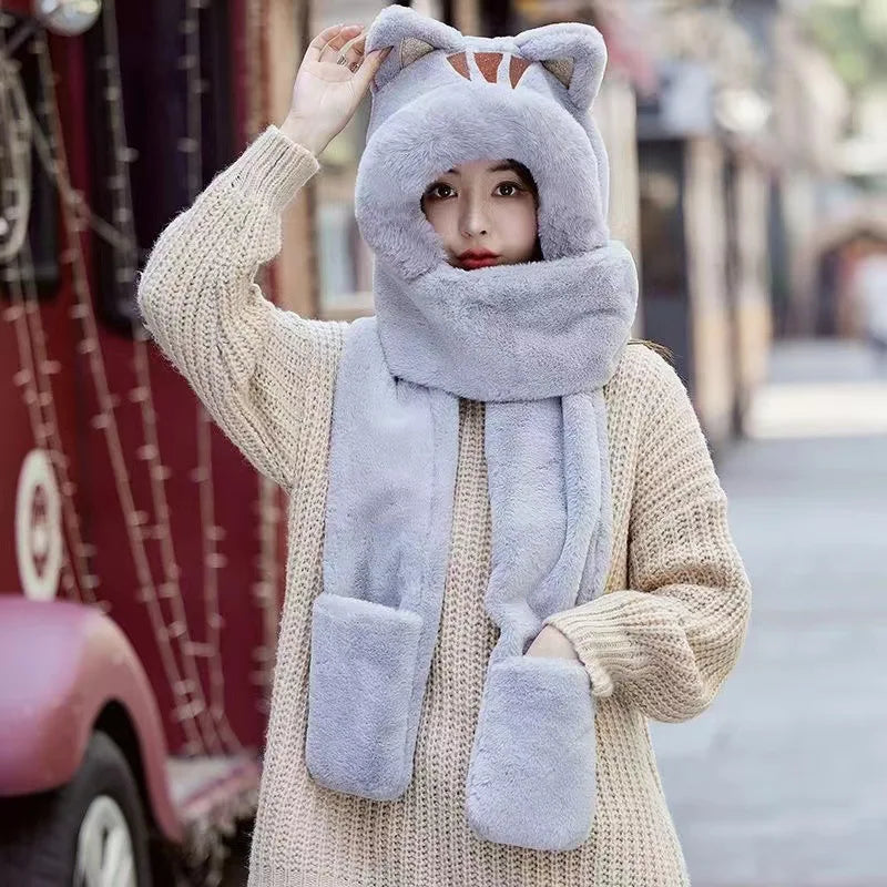 Person wearing a gray cat-themed hat and scarf set on a street background