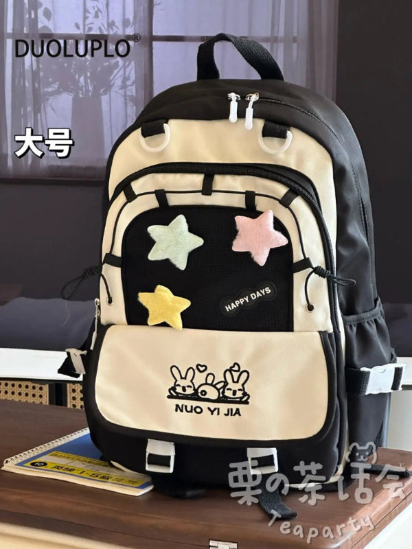 Kawaii backpack with star designs on a wooden surface.