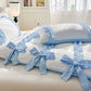 White duvet cover with Blue bows and ribbons on a bed in a bedroom setting.