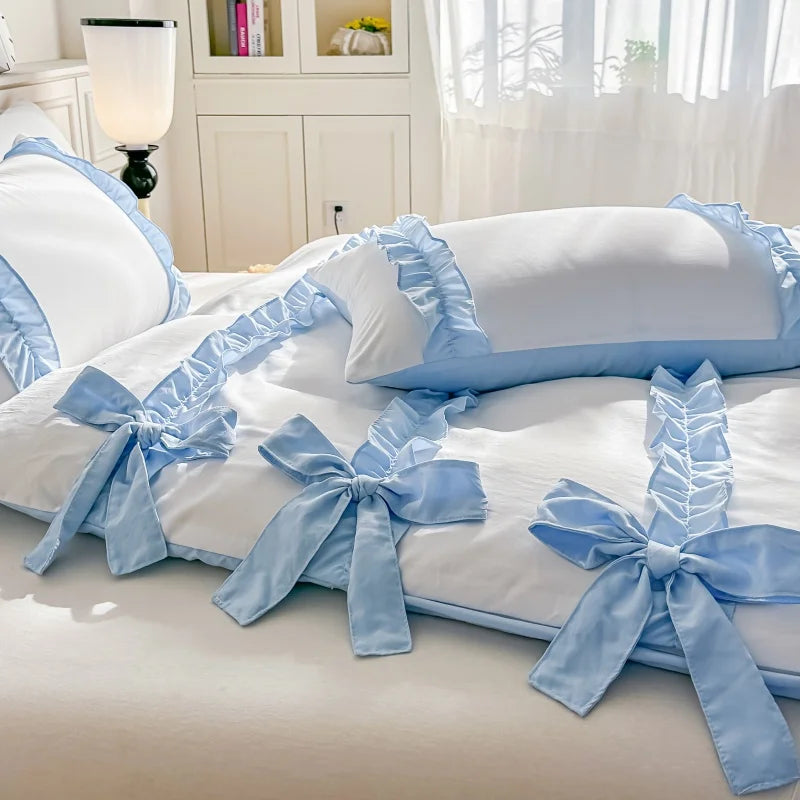 White duvet cover with Blue bows and ribbons on a bed in a bedroom setting.