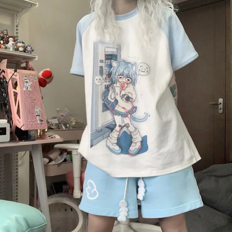 A person wearing a light blue and white raglan t-shirt with a large anime character graphic on the front, paired with matching light blue shorts in a bedroom setting.