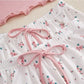 Floral bottoms and shorts with pink bows on a light background