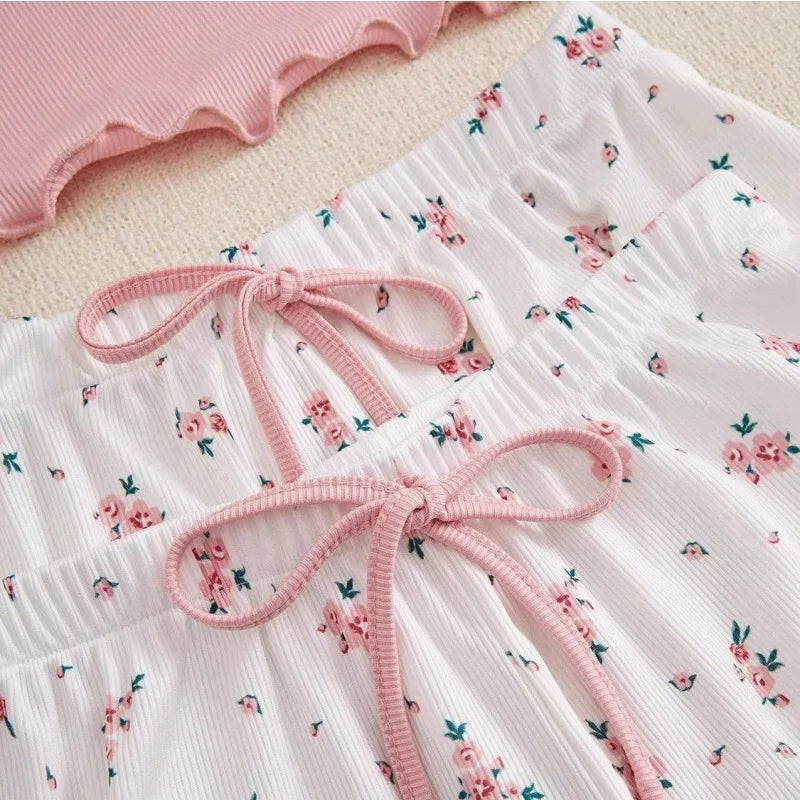 Floral bottoms and shorts with pink bows on a light background