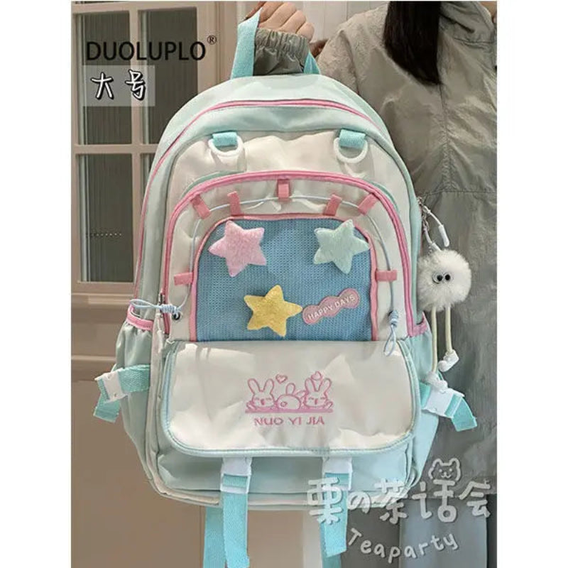 kawaii Light blue backpack with star designs and visible brand logo, held by a person.