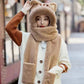 Person wearing a kawaii beige winter cat hat, scarf, and gloves with a blurred background