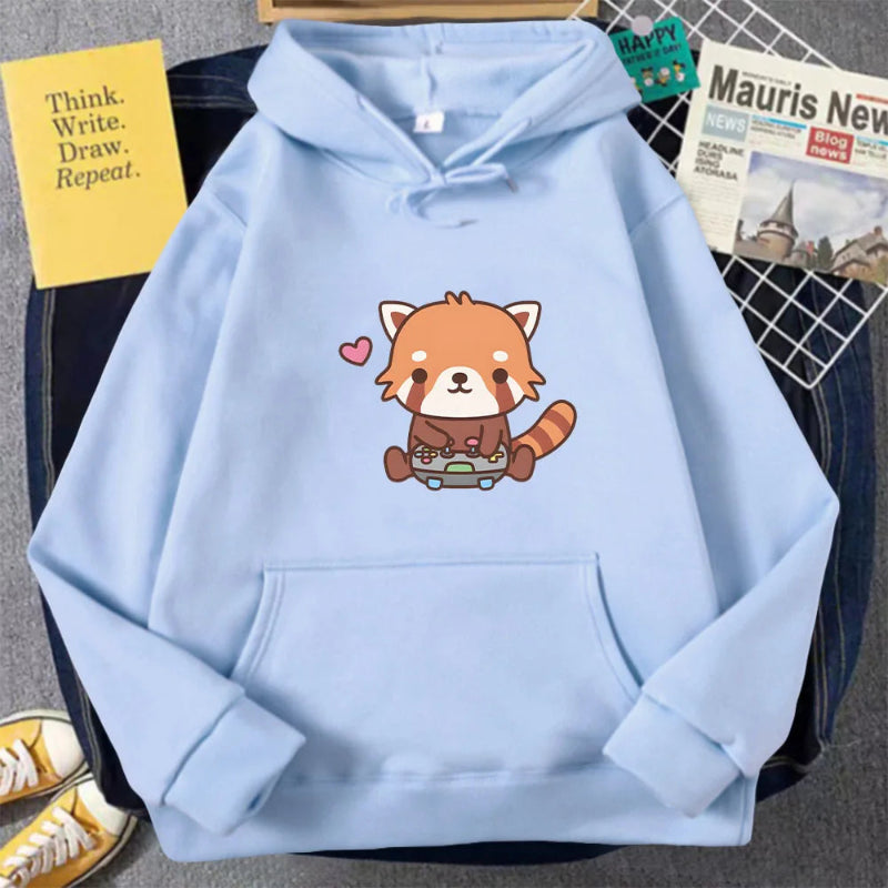 Light blue hoodie with a red panda design on a surface with books and a shoe.