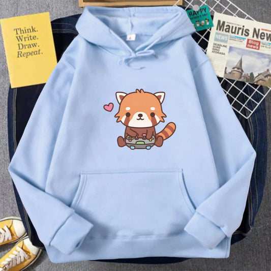 Light blue hoodie with a red panda design on a surface with books and a shoe.