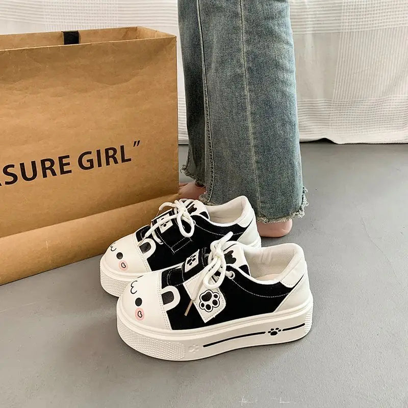 cute cat Black and white sneakers with cartoon design on a gray floor next to a brown paper bag 