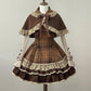A brown and beige plaid Lolita-style dress displayed on a mannequin, featuring a matching brown cape with lace trim, striped sleeves, and a ruffled skirt.