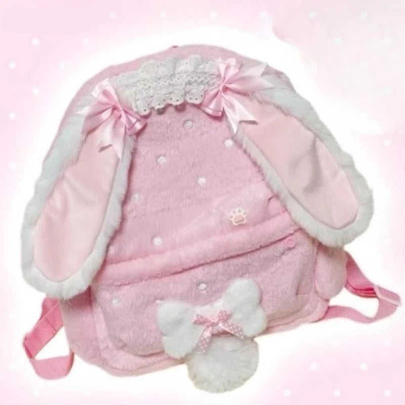 Pink backpack with bunny ears and bow on a light pink background