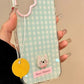 Phone case with checkered pattern, cartoon dog, and 'Sweet Memory' text held by a hand.