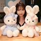woman sitting with the Miss Usagi Plushies, in both white and pink design and the white and blue design.