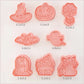 Set of Halloween-themed cookie cutters with measurements on a light pink background