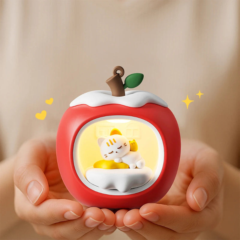 Red apple-shaped night light with a Kawaii cat snuggled inside  held by hands against a beige background