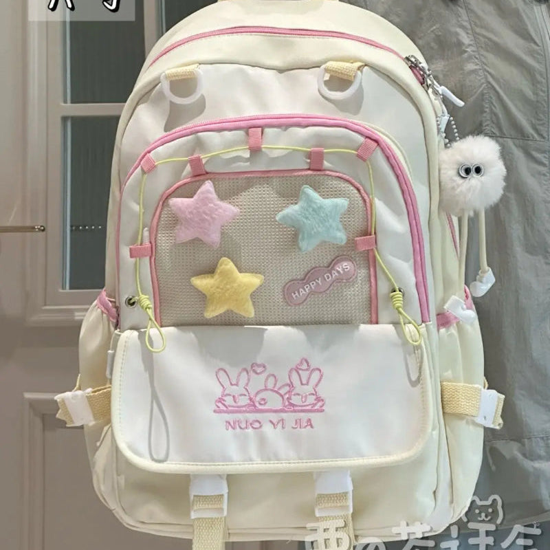 Backpack with star designs and visible brand logo, held by a person.