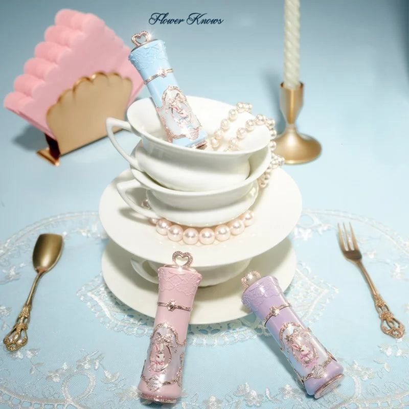 Decorative lip balms on a tea cup with pearls and a light blue background