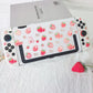White gaming controller with strawberry pattern on a white surface