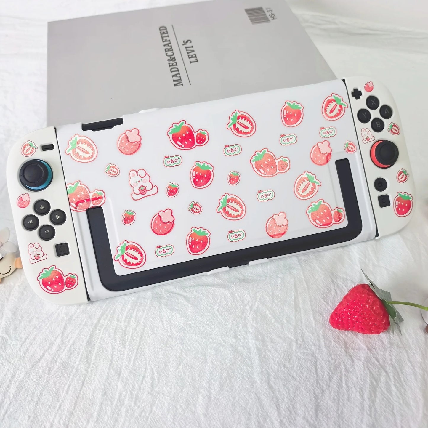 White gaming controller with strawberry pattern on a white surface
