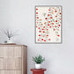 Framed floral artwork on a wall above a wooden cabinet with a plant.