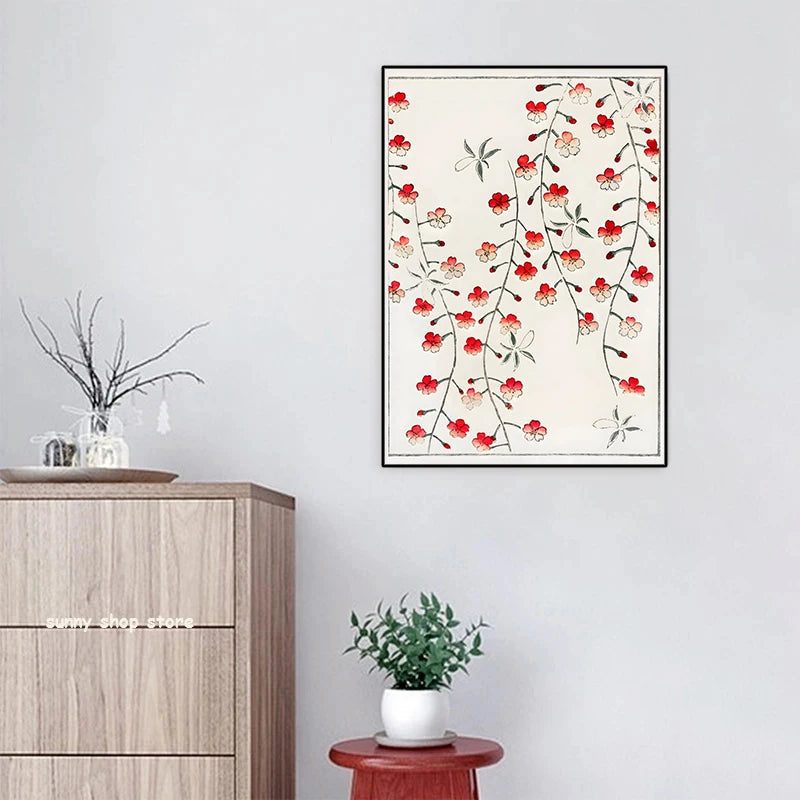 Framed floral artwork on a wall above a wooden cabinet with a plant.