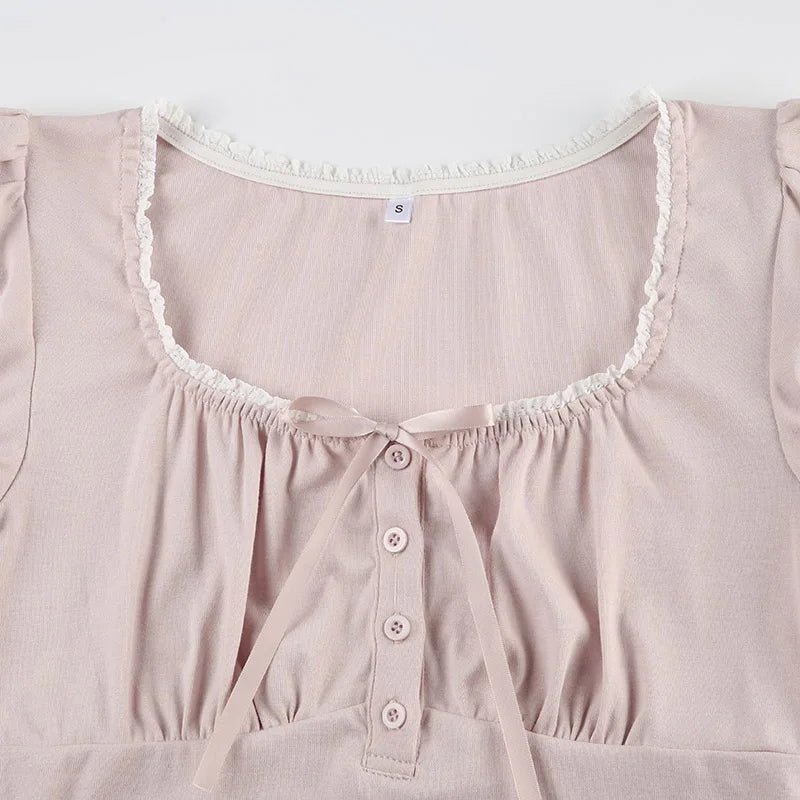 Close-up of a light pink top with lace trim on a white background