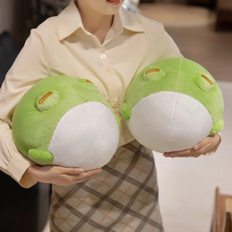 Woman holding two Kawaii round frog plushies
