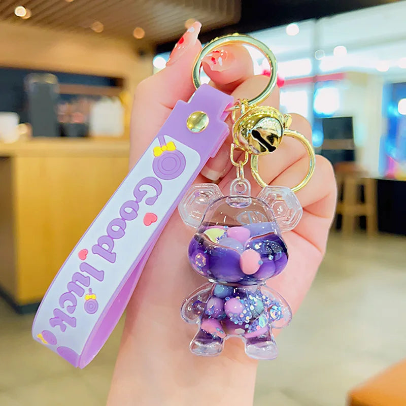 Keychain with a cartoon character and 'Good Luck' text held in a hand.