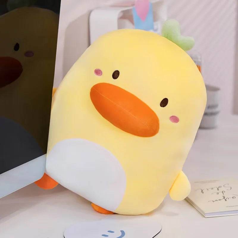 Kawaii Derpy Duck Plushie displayed on a desk top peeking out from behind a computer monitor. 