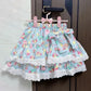 Blue skirt with colorful pattern and lace trim hanging on a door handle.
