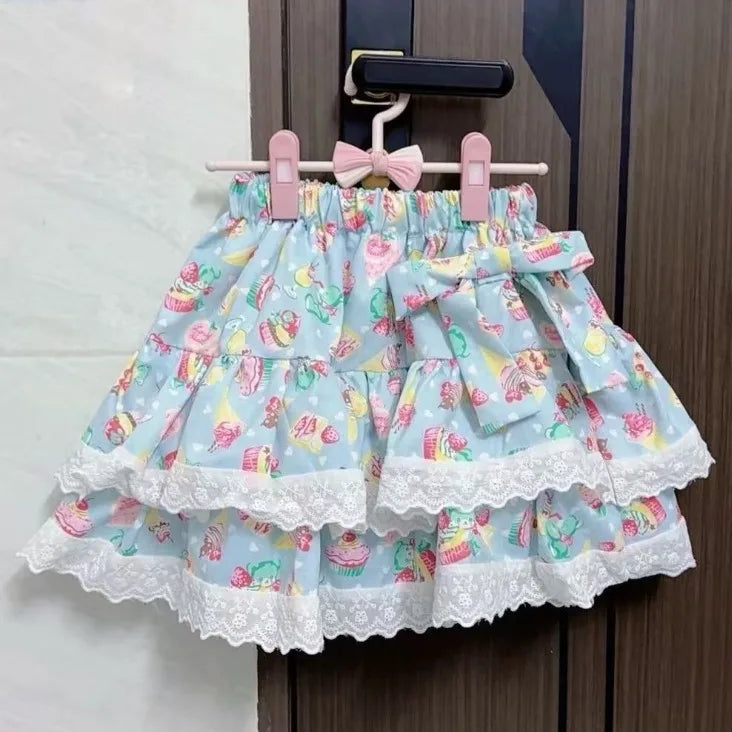 Blue skirt with colorful pattern and lace trim hanging on a door handle.