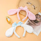 Kawaii Bunny Ears Headbands, being displayed flat on a table, the pink edition and the white and blue edition.