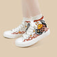 White high-top canvas sneakers with a Japanese koi fish and wave pattern in red, black, and gold, shown on a model's feet against a solid beige background.