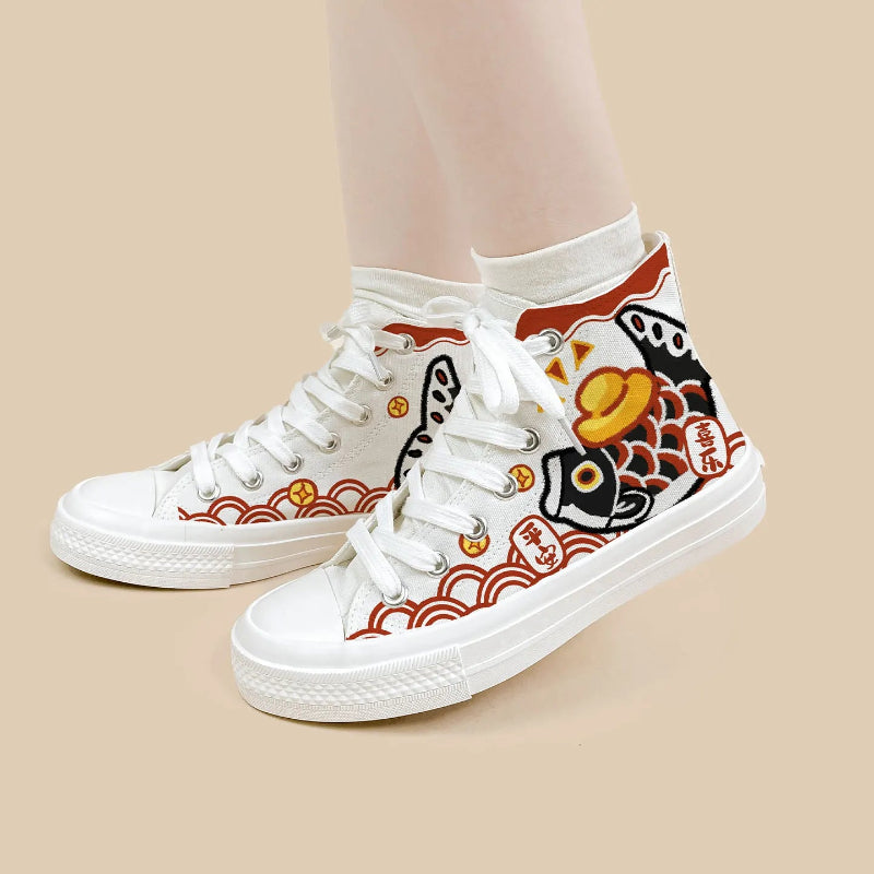 White high-top canvas sneakers with a Japanese koi fish and wave pattern in red, black, and gold, shown on a model's feet against a solid beige background.