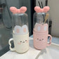 Two cute glass bottles with pink bunny ears on a reflective surface.