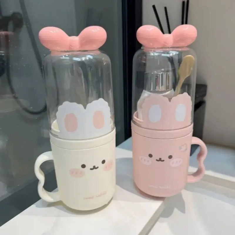 Two cute glass bottles with pink bunny ears on a reflective surface.