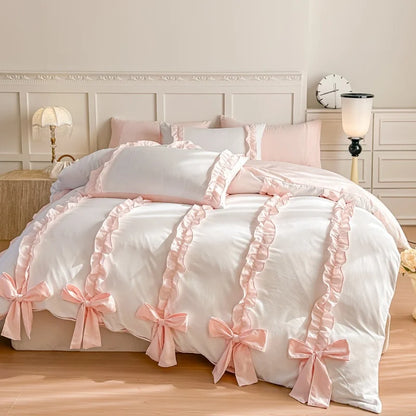 White bedspread with pink ruffles and bows in a bedroom setting.