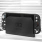 Black Nintendo Switch device on a white surface with a blurred background