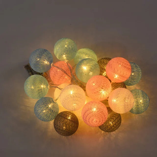 String of colorful cotton ball lights on a dark background