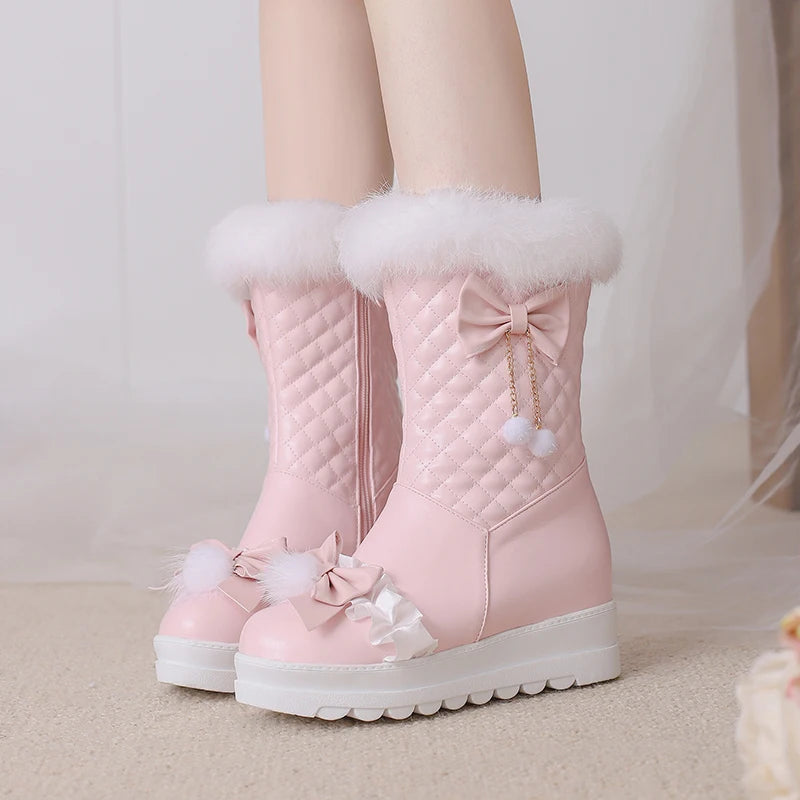 Pink winter boots with white fur trim and decorative bows on a neutral background