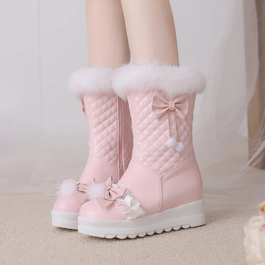 Pink winter boots with white fur trim and decorative bows on a neutral background
