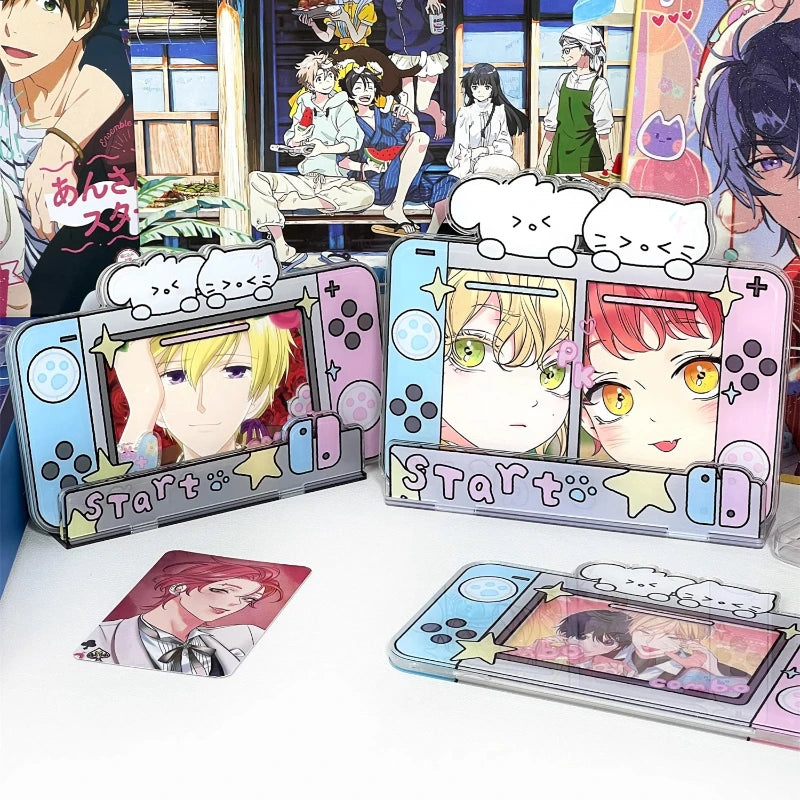 Three anime-themed Nintendo Switch-style standees and a small card are displayed on a white tabletop. The stands feature colorful character portraits, decorative cloud stickers, and game controller graphics.