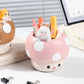 Cute mushroom-shaped pen holder with stationery items on a desk.
