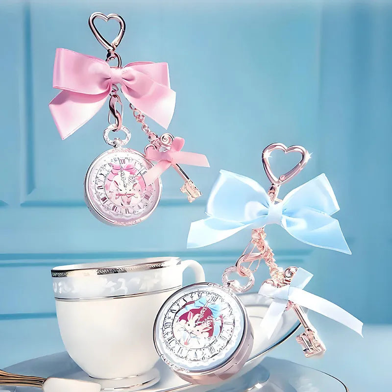 Two decorative keychain lip balms with bows and a teacup on a light blue background
